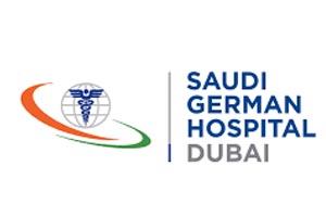 Table with chairs and flowers located near lounge area and kitchen in spacious room of contemporary apartment